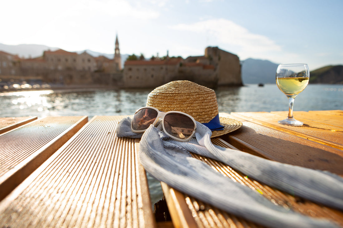 Glass of white wine on a wooden table overlooking a seaside town in Croatia