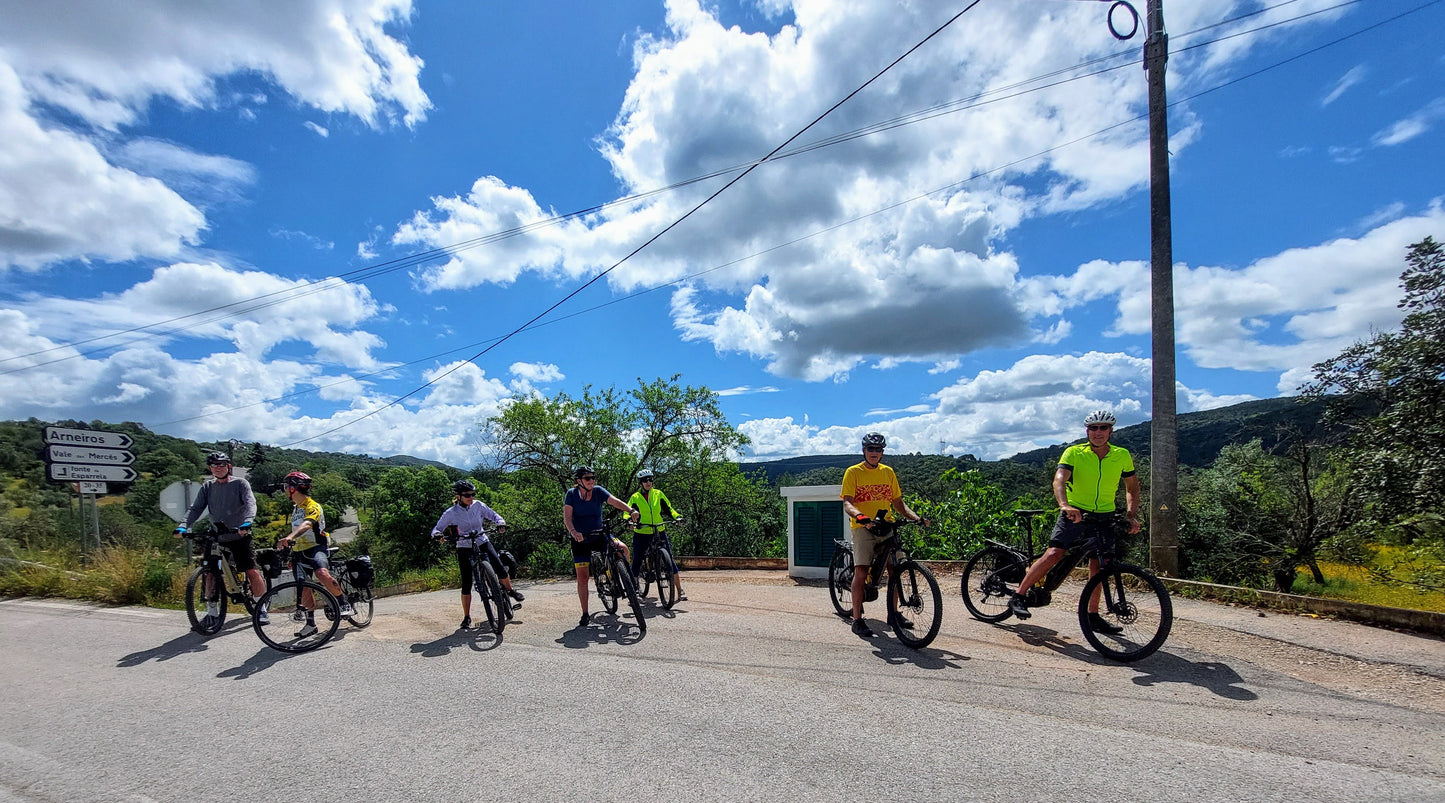 Group of cyclists on a country road with a scenic background in the Algarve