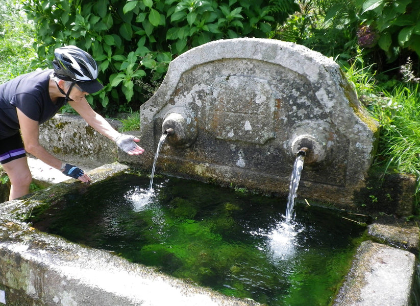 Cyclist at an ancient water fountain in the Minho region in Portugal