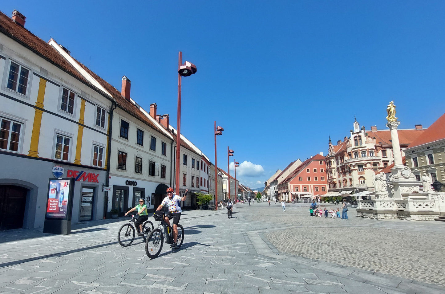 Couple cycling through a pretty town center on a bike tour in Slovenia